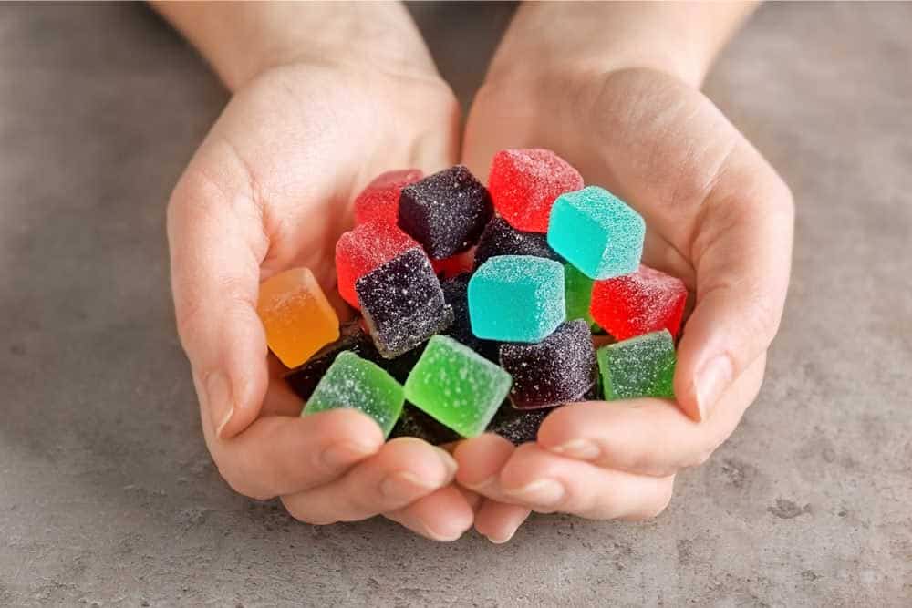 person holding amanita muscaria gummy cubes