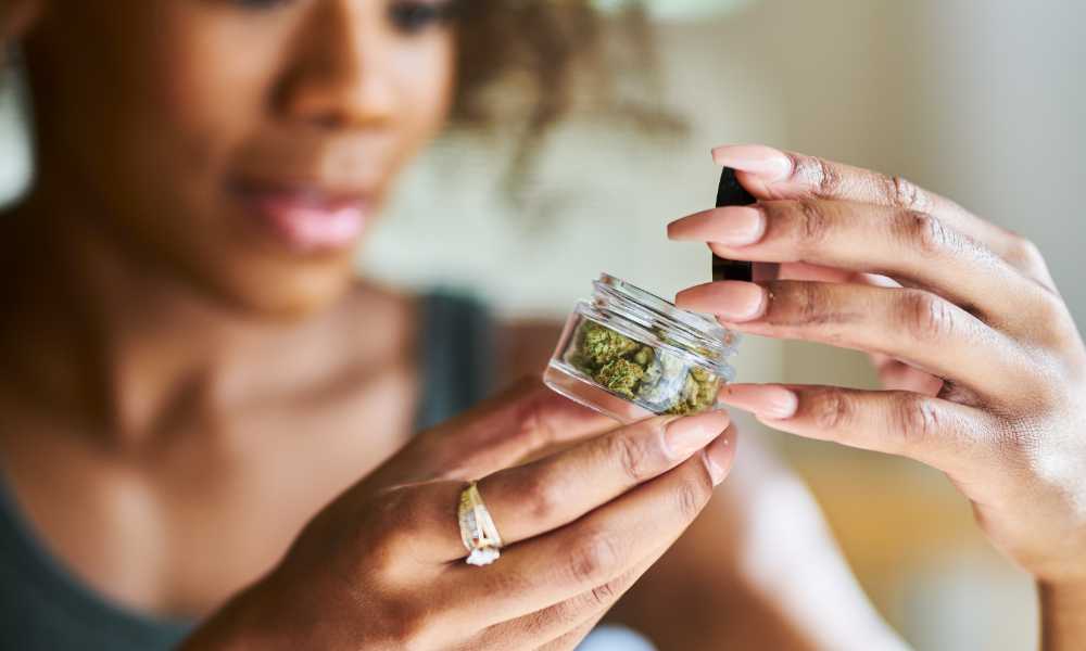 woman examining jar of cannabis