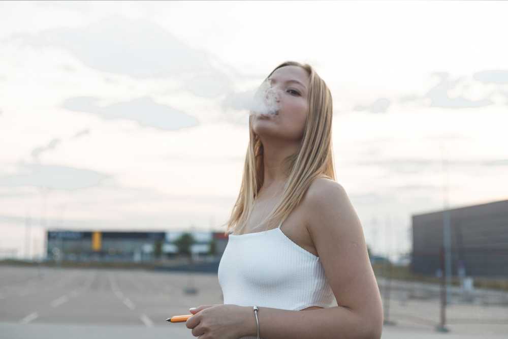 woman vaping in white top