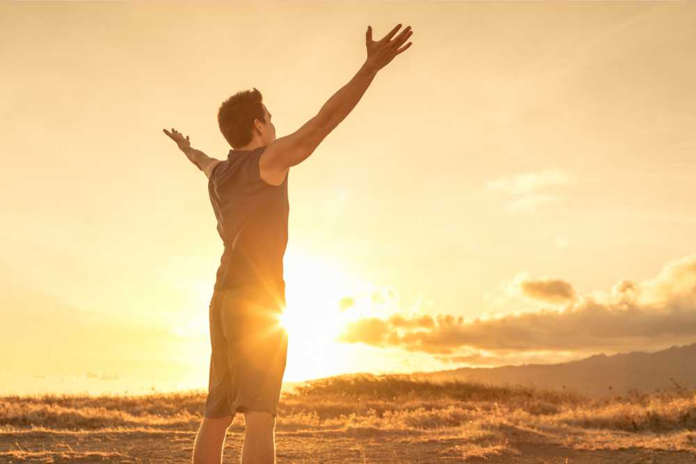 young man outdoors feeling energized sunset in back