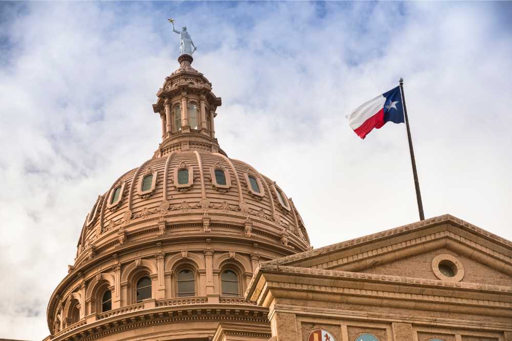 texas state capitol with texas flag