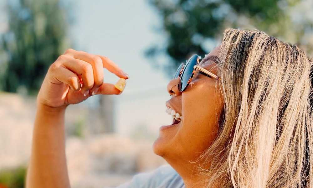 happy woman taking one gummy cube