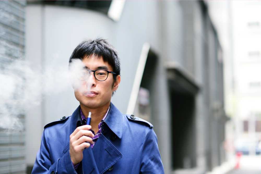 asian man with glasses vaping