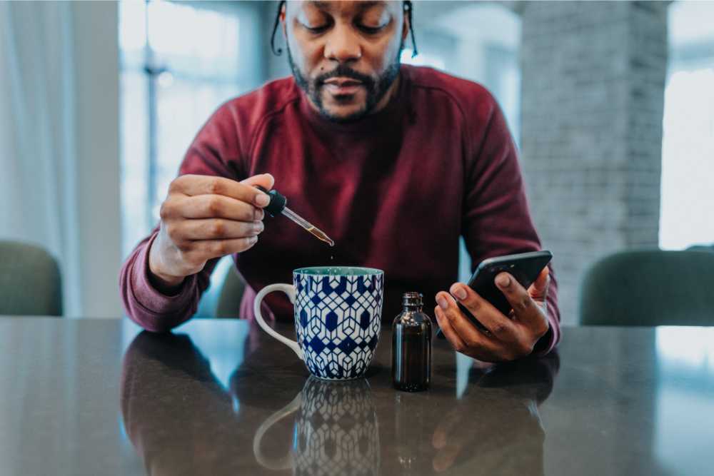 man adding cannabis oil to coffee