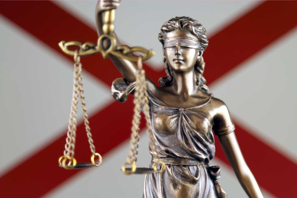 alabama flag on background with lady justice