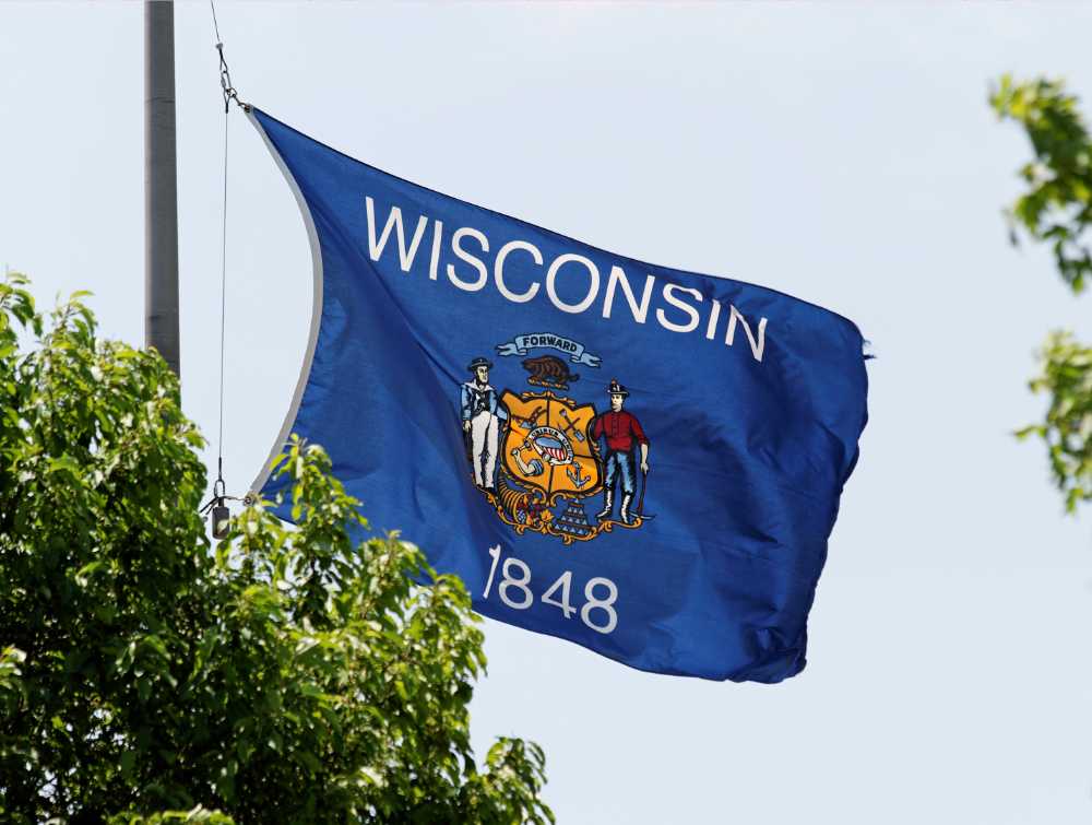 wisconsin state flag billowing in blue sky